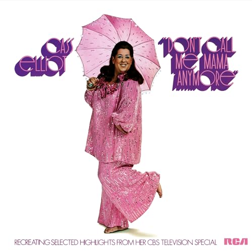 Cass Elliot in a sparkling pink outfit holding a pink umbrella against white background.
