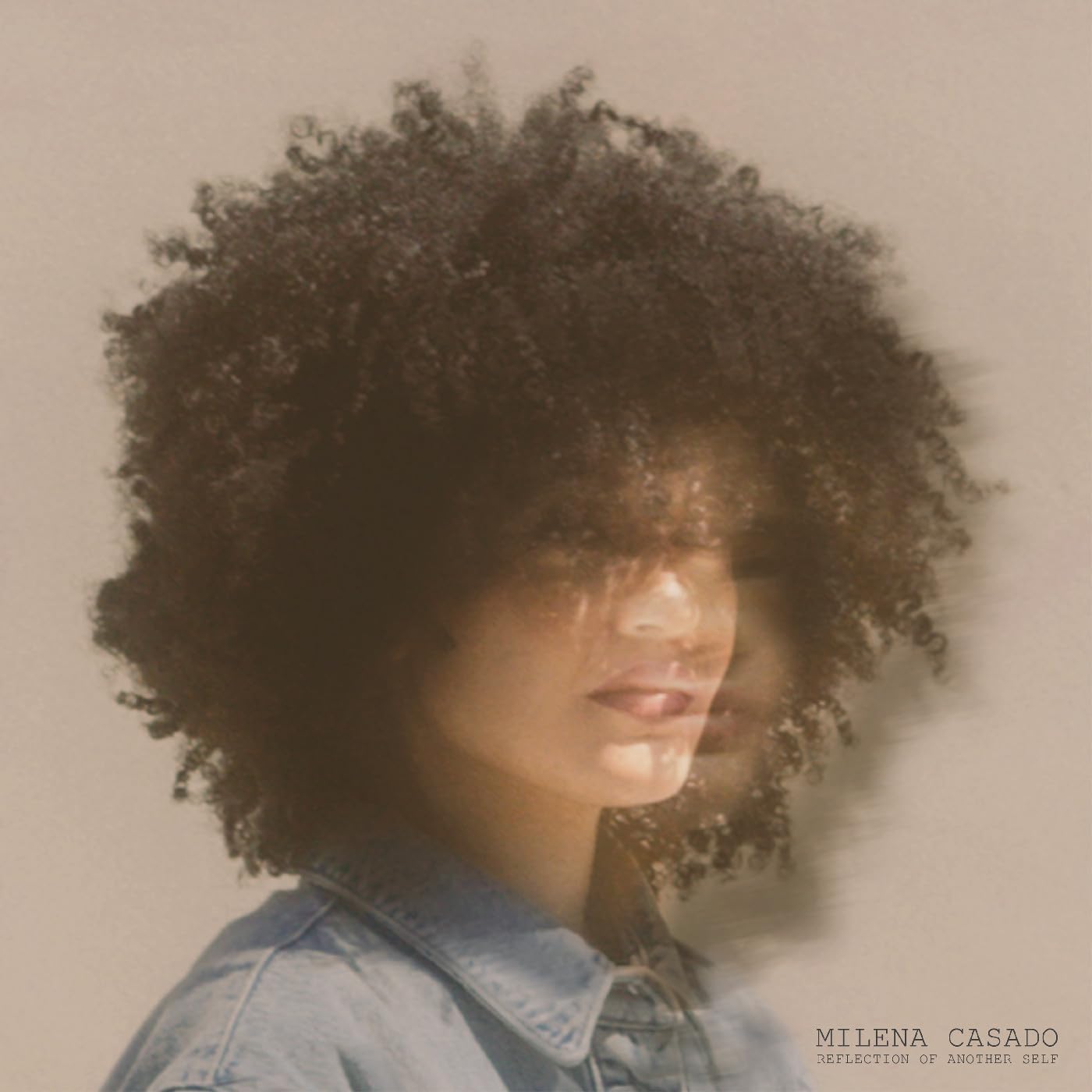 Woman with large afro and blurred, overlapping self-portrait.