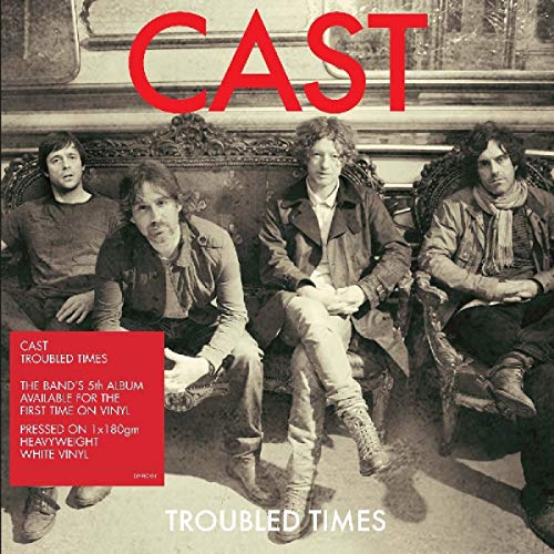 Cast band members seated on an ornate couch, album cover art.