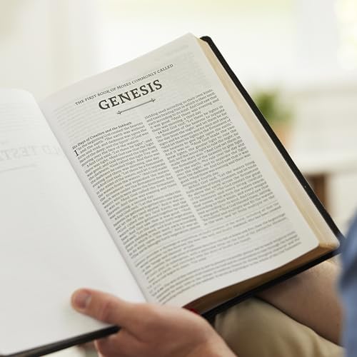 Open Catholic Bible displaying the book of Genesis, crimson cover visible.