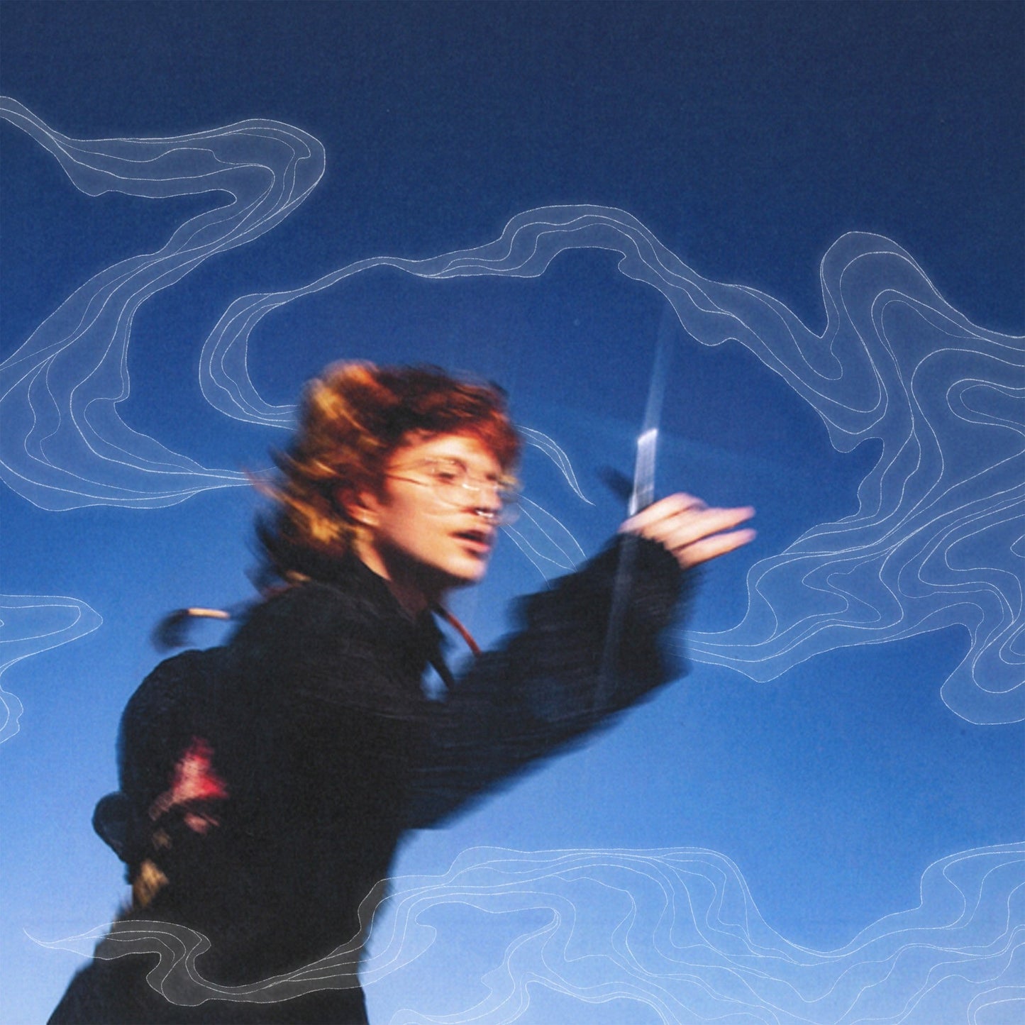 Blurry image of a person with glasses holding scissors against a blue background.