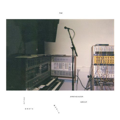 A recording studio setup with modular synthesizers, a keyboard, and a microphone on stand.