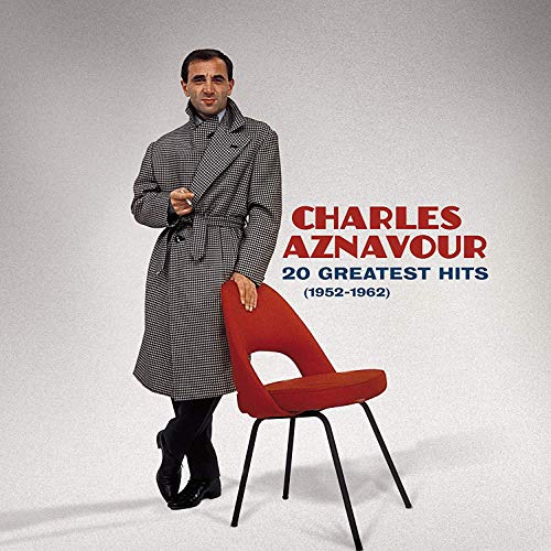 Charles Aznavour album cover featuring a man in a coat and red chair.