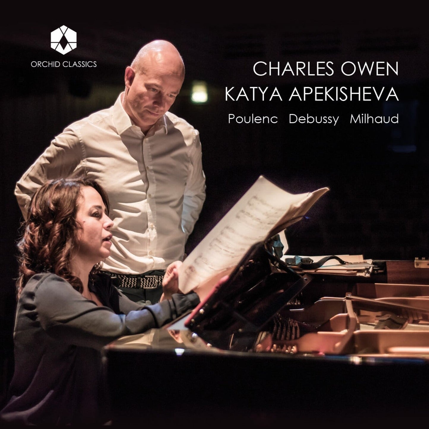 Two pianists, Charles Owen and Katya Apekisheva, playing a grand piano.