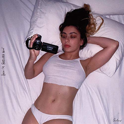 Charli XCX album cover: woman with camera on white bedding.