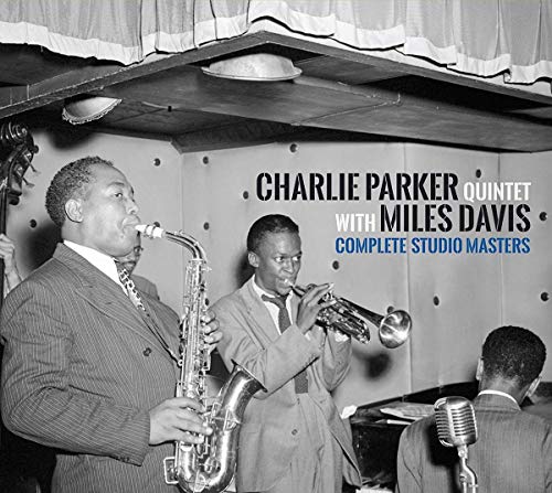 Black and white photo of Charlie Parker playing saxophone and Miles Davis playing trumpet.