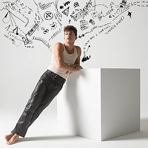 Charlie Puth leaning against a white cube with sketched musical notes.