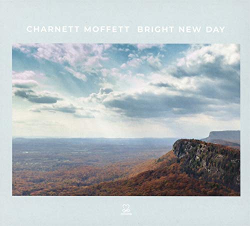 "Album cover with a landscape photo of mountains and cloudy sky on a light blue background."