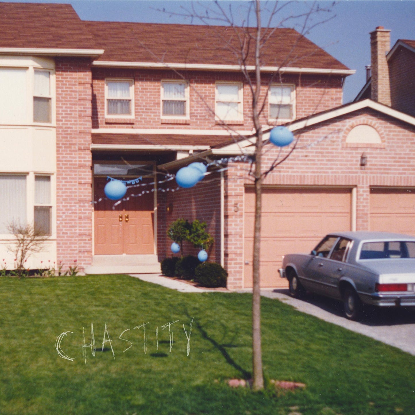A brick house with blue balloons and a car, with the word Chastity written below.