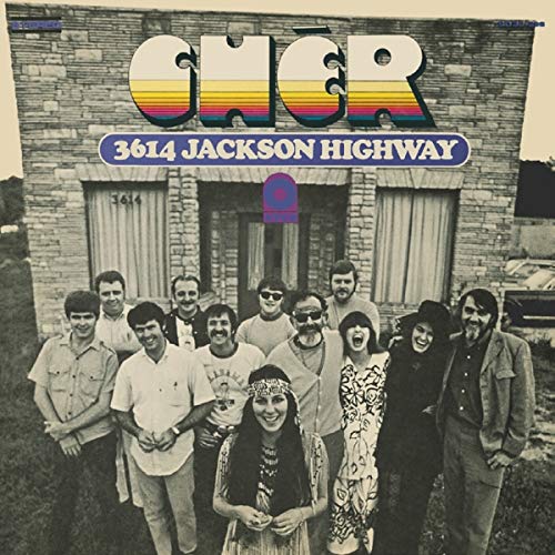 "Album cover featuring a black-and-white group photo in front of a brick building."