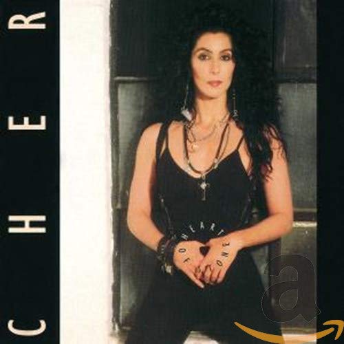 Cher with long dark hair wearing a black outfit and necklaces on album cover.