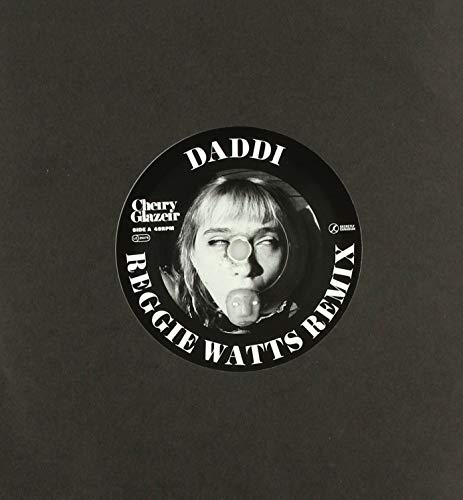 A black vinyl record label featuring a person's face with text around the edge.