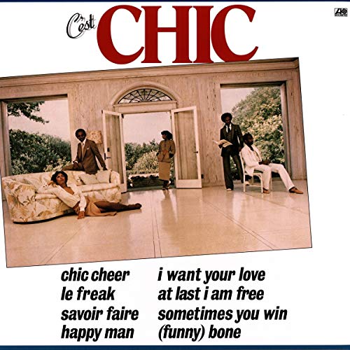 "Album cover with a photo of four people in a luxurious room, listing song titles."