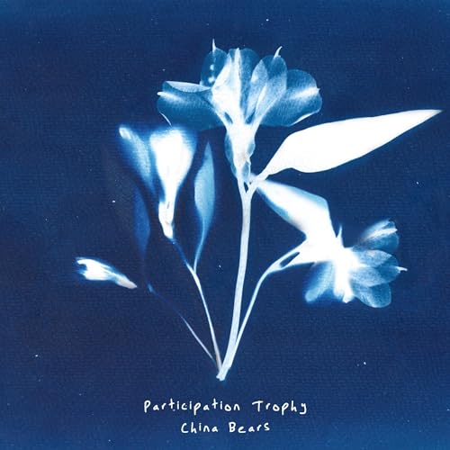 Cyanotype print of a flower on a dark blue background with white text below.