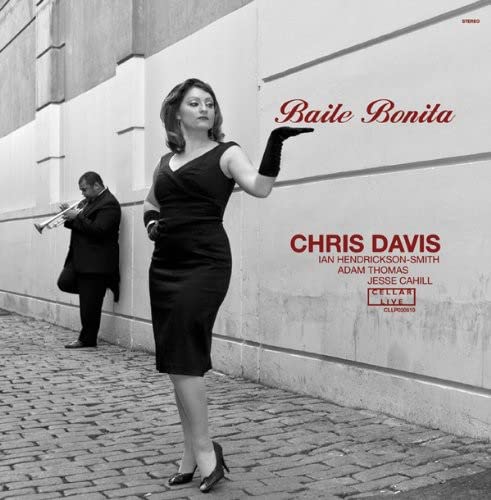 CD cover: woman in black dress, man playing trumpet, brick wall.