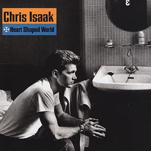 Chris Isaak sits in a bathroom next to a sink on this album cover.