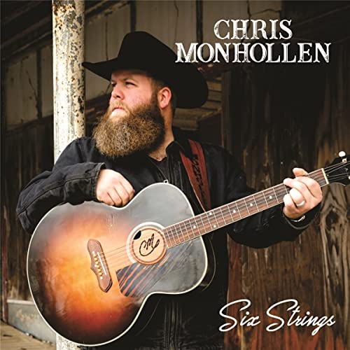 Bearded man in a hat playing an acoustic guitar.
