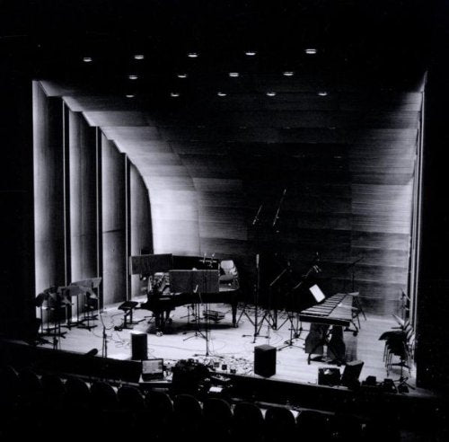 Black and white image of a stage with a grand piano and various instruments.