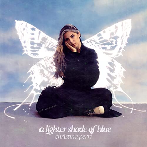 Christina Perri album cover with artist seated before a butterfly illustration.