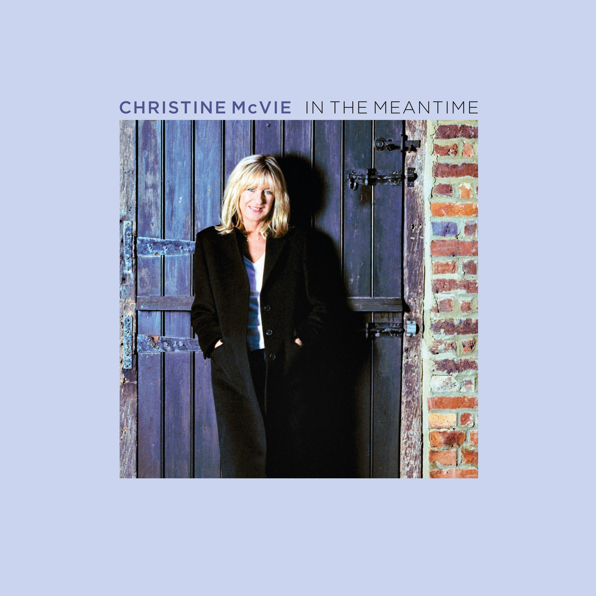 "Christine McVie album cover with a woman standing against a wooden door."