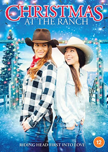 Two women in cowboy hats and jeans stand together against a snowy ranch background.