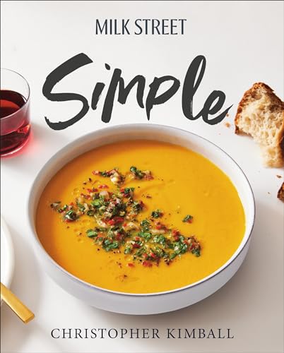 Cookbook cover with bowl of orange soup, bread, and red wine.