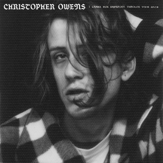 Black and white portrait of musician Christopher Owens with plaid background.
