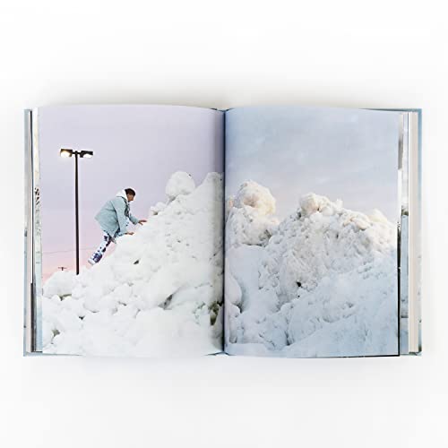 Open album booklet with a person climbing a large snow pile.