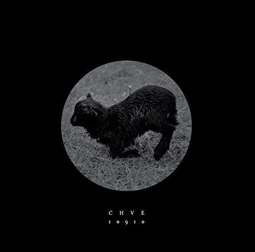 Black and white image of a lamb on grass, centered on a black background.