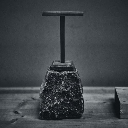 Black and white image of a stone sculpture resembling a cross.