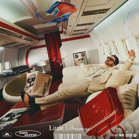 Album cover: man reclining in an airplane, holding a newspaper.