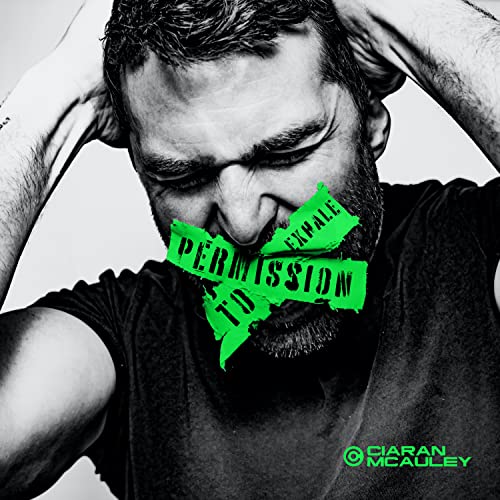 Black and white portrait of a man with green tape over his mouth.