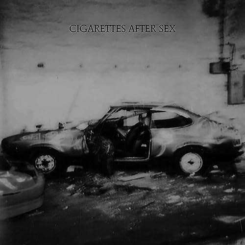 Black and white album cover featuring a damaged, burned car.