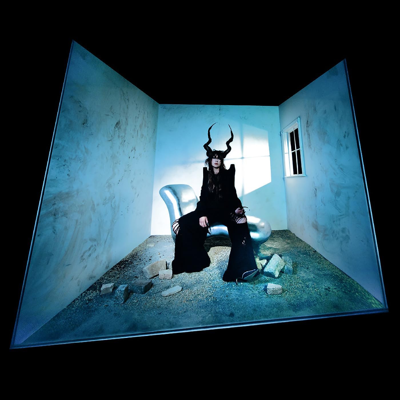 Person with horned headwear sits in a blue, fragmented room.