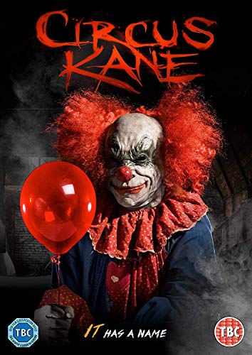 A scary clown with red hair holds a red balloon against a dark background.