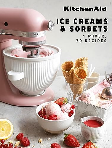 A pink KitchenAid stand mixer with ice cream, berries, and cones on a table.
