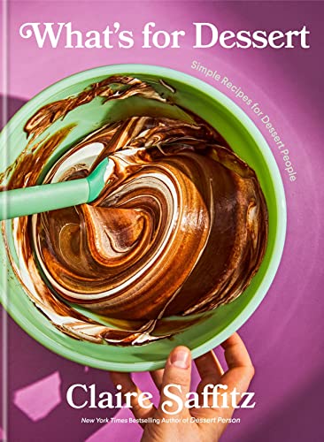 A green bowl of swirled chocolate batter being stirred on a purple background.