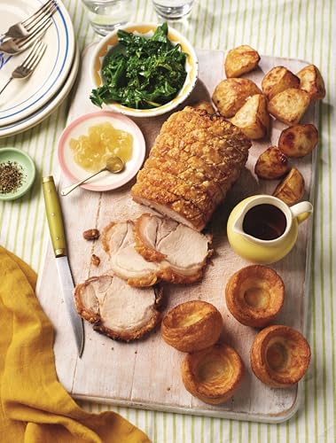 Roasted pork with potatoes, greens, Yorkshire puddings, and apple sauce.