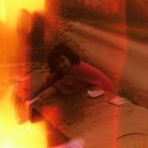 Blurred album cover featuring a person lying down in warm tones.