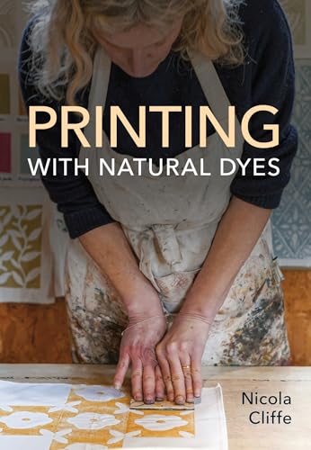 A woman in an apron printing a floral pattern onto fabric with natural dyes.