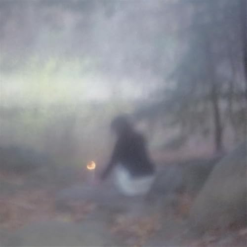 Blurry CD cover with a person sitting outdoors in fog.