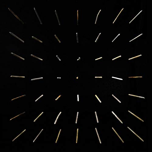 Black album cover with radiating, fragmented lines and a central yellow spot.