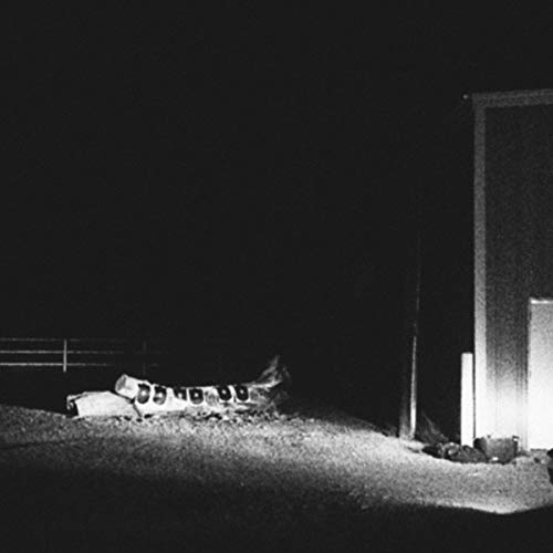Black and white album cover depicting a crashed airplane at night.