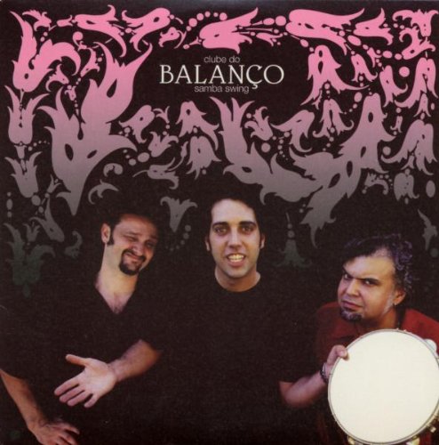 "Album cover with three men, one holding a drum, against a dark background."