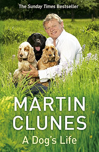 Book cover: Man with three dogs in a field of green grass.
