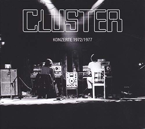 Cluster album cover: musicians with electronic equipment on a stage.