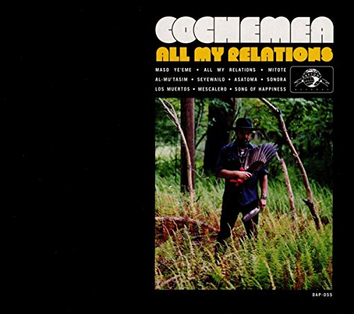 Album cover with a man in a forest, wearing a hat and holding a guitar.