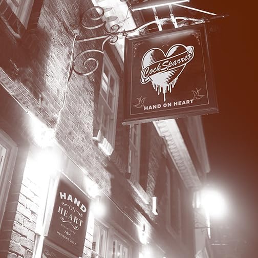 Black and white photo of a pub sign reading "Cock Sparrer - Hand On Heart".