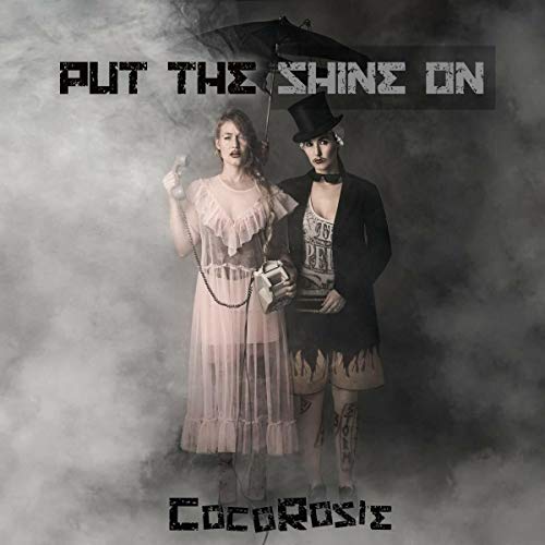 "Album cover featuring a man and woman in steampunk attire amidst cloudy background."