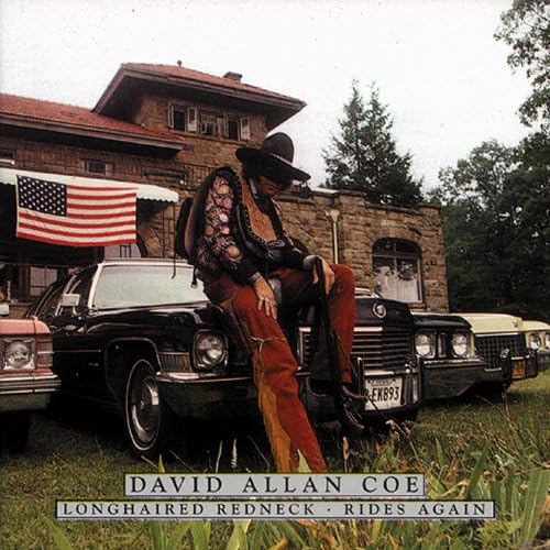David Allan Coe poses with cars and an American flag on album cover.